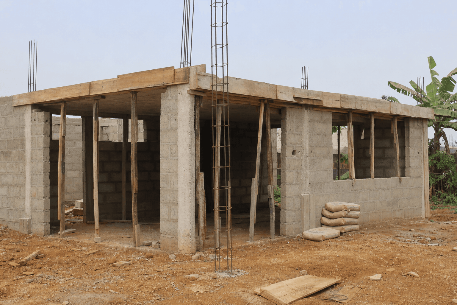 Chantier en élévation, banlieue de Douala. La dalle, les agglos et le fer sont les trois lignes où l'écart se cache le plus souvent.